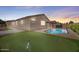 This backyard features a pool, putting green and patio, perfect for outdoor entertaining and relaxing at 21075 E Estrella Rd, Queen Creek, AZ 85142