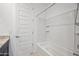 This bathroom includes a shower and bath combo with shelving, as well as a full door for privacy at 21075 E Estrella Rd, Queen Creek, AZ 85142