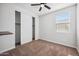 This bedroom has neutral carpet, a ceiling fan, a closet, and a window to let in natural light at 21075 E Estrella Rd, Queen Creek, AZ 85142