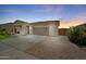 Attractive home featuring a two-car garage, brick driveway, and drought-tolerant landscaping at 21075 E Estrella Rd, Queen Creek, AZ 85142