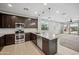 Well-equipped kitchen with stainless steel appliances, granite countertops, and dark wood cabinets at 21075 E Estrella Rd, Queen Creek, AZ 85142