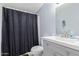 Small bathroom with gray walls, shower with black curtain, toilet, sink, and mirror at 22216 W Bajada Dr, Wittmann, AZ 85361