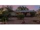 Home exterior featuring desert landscaping with mature plants, covered front porch, and gravel yard at 22216 W Bajada Dr, Wittmann, AZ 85361