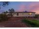 Lovely single story home with a cozy atmosphere and well-maintained landscaping at dusk at 22216 W Bajada Dr, Wittmann, AZ 85361