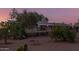 Home exterior featuring mature plants and landscaping around a gravel yard in the desert at 22216 W Bajada Dr, Wittmann, AZ 85361