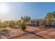 Expansive front yard features desert landscaping, gravel, a charming home, and ample space at 22216 W Bajada Dr, Wittmann, AZ 85361