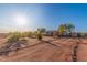 Expansive front yard features desert landscaping, gravel, a charming home, and ample space at 22216 W Bajada Dr, Wittmann, AZ 85361