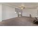 Open living area featuring neutral carpet, white walls, and a peek into the dining space at 22216 W Bajada Dr, Wittmann, AZ 85361