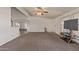 Large, open living room featuring neutral carpet, a ceiling fan, and a view into the dining area at 22216 W Bajada Dr, Wittmann, AZ 85361
