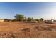 Expansive lot with red dirt and sparse vegetation and a variety of vehicles at 22216 W Bajada Dr, Wittmann, AZ 85361
