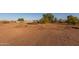 Wide, expansive lot view with red dirt, sparse vegetation, and blue sky at 22216 W Bajada Dr, Wittmann, AZ 85361