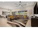 Living room with large sectional sofa, striped rug, ceiling fan, and sliding glass doors to the yard at 23060 E Sonoqui Blvd, Queen Creek, AZ 85142