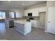 Modern kitchen features stainless steel appliances, a central island, and sleek white cabinets at 23214 W Miami St, Buckeye, AZ 85326