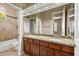 Bathroom vanity featuring double sinks, granite countertops, and a large framed mirror at 2370 W Maplewood St, Chandler, AZ 85286
