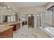 Luxurious bathroom featuring double vanities, a soaking tub, and a walk-in shower at 2370 W Maplewood St, Chandler, AZ 85286
