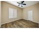 This bedroom features wood flooring, a ceiling fan, and a window with white shutters at 2370 W Maplewood St, Chandler, AZ 85286