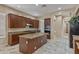 Bright kitchen offers a large island, stainless steel appliances, granite counters, and wood cabinetry for ample storage at 2370 W Maplewood St, Chandler, AZ 85286