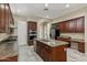 Spacious kitchen features a central island with granite countertops, wood cabinets, and stainless steel appliances at 2370 W Maplewood St, Chandler, AZ 85286