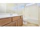 Bright bathroom featuring a vanity with storage, a shower-tub combo, and neutral tile flooring at 23853 W Hammond Ln, Buckeye, AZ 85326
