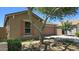 Beautiful home exterior with desert landscaping, mature trees, and a two-car garage at 23853 W Hammond Ln, Buckeye, AZ 85326