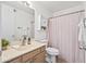 This stylish bathroom features a vanity, commode and bathtub with shower and soft pink shower curtain at 255 S Kyrene Rd # 139, Chandler, AZ 85226
