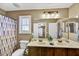 Bathroom featuring double sinks, wooden cabinets and a large mirror with decorative lighting at 31133 N 132Nd Ln, Peoria, AZ 85383