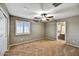 Empty bedroom with carpet, ceiling fan, and an adjoining bathroom at 31133 N 132Nd Ln, Peoria, AZ 85383