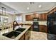 Stylish kitchen featuring granite counters, dark cabinets, and modern appliances at 31133 N 132Nd Ln, Peoria, AZ 85383