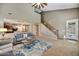 Open-concept living room featuring a staircase, access to kitchen, and lots of natural light at 31133 N 132Nd Ln, Peoria, AZ 85383