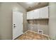 Mudroom features tiled floor and storage cabinets above the washer and dryer hookups at 31133 N 132Nd Ln, Peoria, AZ 85383