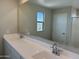 Bathroom featuring double sinks, a large mirror, and a separate shower area at 3125 S 232Nd Ave, Buckeye, AZ 85326