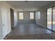 Spacious living room with gray tile flooring, neutral paint, and a sliding glass door at 3125 S 232Nd Ave, Buckeye, AZ 85326