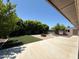 Backyard featuring artificial turf, a brick patio, and a fire pit, with trees and shrubs in the background at 3145 W Acoma Dr, Phoenix, AZ 85053