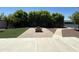 Backyard featuring artificial turf, a brick patio, and a fire pit, with trees and shrubs in the background at 3145 W Acoma Dr, Phoenix, AZ 85053