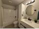 Updated bathroom featuring tile floors, a shower-tub combo, and a modern vanity with a round mirror at 3145 W Acoma Dr, Phoenix, AZ 85053