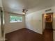 Bedroom featuring wood floors, a ceiling fan, a window, and a closet, with a view of another room at 3145 W Acoma Dr, Phoenix, AZ 85053