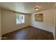 Bedroom featuring wood floors, a window, a light fixture, and a decorative piece on the wall at 3145 W Acoma Dr, Phoenix, AZ 85053