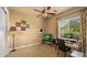 Bright bedroom with two TVs, a ceiling fan, a well-lit desk area, and ample natural light at 36813 N 109Th Way, Scottsdale, AZ 85262