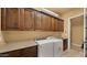 Spacious laundry room equipped with full-size washer and dryer and custom cabinets at 36813 N 109Th Way, Scottsdale, AZ 85262