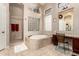 Elegant bathroom featuring a soaking tub with tile surround, walk-in shower, and vanity area at 4041 N Silver Ridge Cir, Mesa, AZ 85207