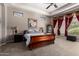 Spacious bedroom with a sleigh bed, ceiling fan, and large windows draped with decorative curtains at 4041 N Silver Ridge Cir, Mesa, AZ 85207
