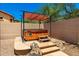Outdoor hot tub with a canopy, set on a stone patio, surrounded by a privacy wall and desert vegetation at 4041 N Silver Ridge Cir, Mesa, AZ 85207