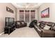 Cozy living room with leather seating, a ceiling fan, and a large TV, ideal for relaxation at 4041 N Silver Ridge Cir, Mesa, AZ 85207