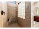 Walk-in shower with tiled walls, a glass block window, and a built-in corner seat at 4041 N Silver Ridge Cir, Mesa, AZ 85207
