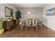 Dining room area featuring tile floors, modern chandelier, and a decorative accent wall at 4108 N 304Th Ln, Buckeye, AZ 85396