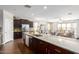 Bright kitchen featuring a large island, modern appliances, and dark cabinetry that opens to the living room at 4108 N 304Th Ln, Buckeye, AZ 85396