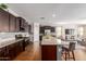 Open kitchen with a large island, stainless steel appliances, and dark wood cabinetry that connects to the living area at 4108 N 304Th Ln, Buckeye, AZ 85396