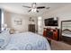 Bright main bedroom featuring soft carpet, neutral walls, and a large decorative mirror, and a ceiling fan at 4108 N 304Th Ln, Buckeye, AZ 85396