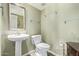 Half bathroom with pedestal sink, toilet, and glass shelving and neutral wall color at 4514 E Verbena Dr, Phoenix, AZ 85044