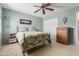 A cozy bedroom featuring a metal bed frame, a ceiling fan, and neutral carpet at 4514 E Verbena Dr, Phoenix, AZ 85044